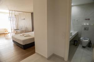 a bedroom with a bed and a bathroom with a sink at VH Executive Suites in Thessaloniki +48 photos