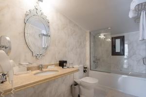 uma casa de banho com um lavatório, um WC e um espelho. em Corfu Holiday Palace em Corfu Town