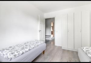 a white bedroom with a bed and white cabinets at Easy and short from the airport in Helsinki