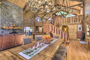 ein großes Wohnzimmer mit einem Tisch und einem Kronleuchter in der Unterkunft Countryside Cabin Retreat with Outdoor Kitchen! 