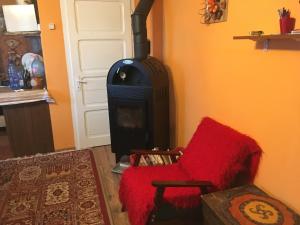 uma sala de estar com um fogão e uma cadeira vermelha em Orange House em Harghita-Bai