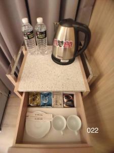 龍潭區的住宿－溫馨汽車旅館，咖啡壶和水瓶,放在柜台上