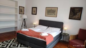 a bedroom with a bed with a red blanket and a chair at Vienna Apartment am Graben in Vienna