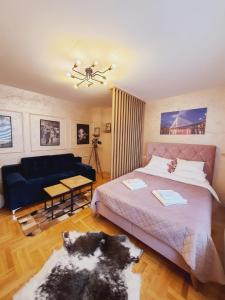 a bedroom with a bed and a blue couch at Apartman Planinski Kutak in Pale