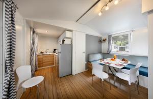 een keuken en eetkamer met een tafel en stoelen bij Albatross Mobile Homes on Camping Eden in San Felice del Benaco