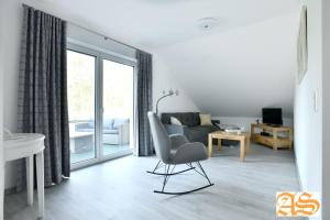 a living room with a chair and a couch at Reiterhof Füllnhausen in Kröge