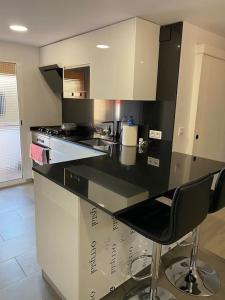 a kitchen with a black and white counter top at Habitaciónes bonitas y cómodas in Hospitalet de Llobregat
