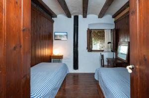 1 dormitorio con 2 camas, mesa y ventana en Flateli Sa Tuna 2, en Begur