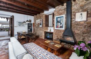 sala de estar con pared de piedra y chimenea en Flateli Sa Tuna 2, en Begur