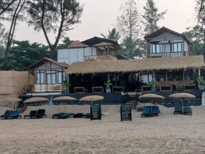 a resort with chairs and umbrellas on a beach at Silent Waves in Agonda