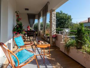 een patio met stoelen en een tafel op een balkon bij Luxury Apartment Vabriga in Vabriga