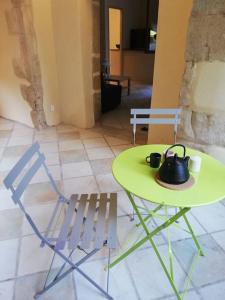 una mesa y una silla con un hervidor de agua. en Gîte largentiere, en Largentière