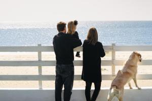 uma família a olhar para a praia com um cão em Anxur Village Camping em Terracina