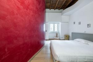 una camera con una parete rossa e un letto di Modern apartment in Campo de Fiori a Roma
