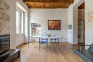 una cucina e una sala da pranzo con tavolo e sedie di Modern apartment in Campo de Fiori a Roma