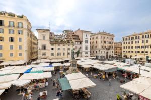 a crowd of people walking around a market with white umbrellas at Modern apartment in Campo de Fiori in Rome