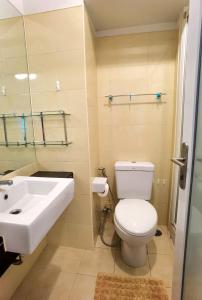 a bathroom with a white toilet and a sink at Rama9 Cozy Apartment in Bangkok
