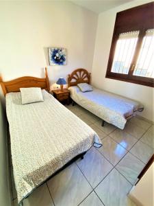 um quarto com 2 camas, uma mesa e janelas em Villa Girasol em Vidreres