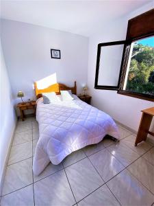 um quarto branco com uma cama e uma janela em Villa Girasol em Vidreres