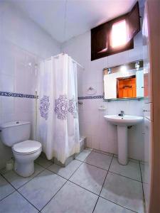 uma casa de banho branca com um WC e um lavatório em Villa Girasol em Vidreres