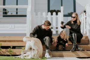 eine Familie, die mit einem Hund auf den Stufen sitzt in der Unterkunft Anxur Village Camping in Terracina