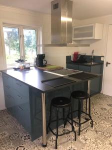 cocina con encimera negra y 2 taburetes en Skattegårdens Gästhus en Falköping