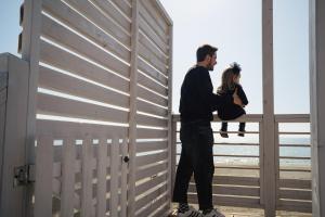 Ein Mann und eine Frau stehen auf einem Balkon in der Unterkunft Anxur Village Camping in Terracina