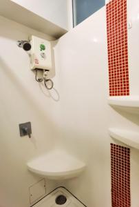 uma casa de banho com WC e uma câmara na parede em Rama9 Cozy Apartment em Banguecoque