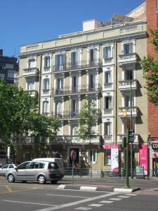 un grande edificio con macchine parcheggiate di fronte di JUAN BRAVO FRANCISCO SILVELA a Madrid