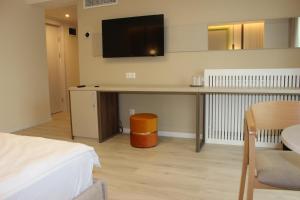 1 dormitorio con escritorio y TV en la pared en Hotel Anina, en Techirghiol