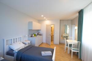 a bedroom with a bed and a table and a kitchen at Apartamentai Baltas gandras in Naisiai