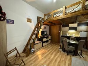 a room with a loft bed and a dining room at Apartman Planinski raj in Kopaonik