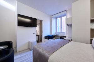 a bedroom with a bed and a tv on the wall at Room 230 Roma Luxury Suites in Rome