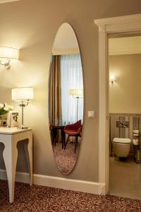 een badkamer met een spiegel in een hotelkamer bij Ratonda Centrum Hotels in Vilnius