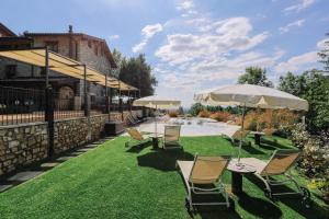 un patio con sillas y sombrillas y una piscina en AGRITURISMO CA' FENILE en Alzano Lombardo
