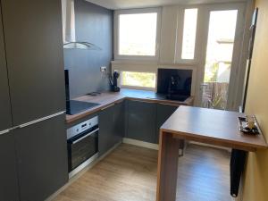 een keuken met een aanrecht en een tafel. bij Appartement situé en centre ville super lumineux in Duinkerke