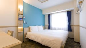 - une chambre avec un lit blanc et une fenêtre dans l'établissement Toyoko Inn Osaka Hankyu Juso-eki Nishi-guchi No.2, à Osaka