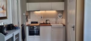 a small kitchen with white cabinets and a stove at Slapen bij Bonanza in Bantega