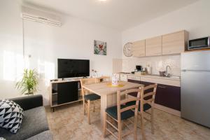 ロヴィニにあるApartman Fumaの部屋に木製のテーブルと椅子が置かれたキッチン