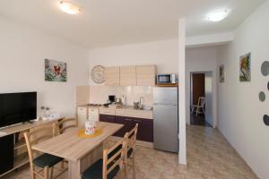 a kitchen and dining room with a table and a refrigerator at Apartman Fuma in Rovinj