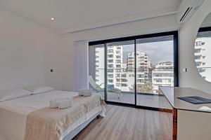 Un dormitorio con una cama y una ventana grande. en Sky Beach Apartment, en Quarteira 23 fotos más