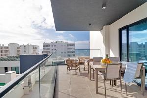 Un balcón con una mesa y sillas en un edificio. en Sky Beach Apartment, en Quarteira