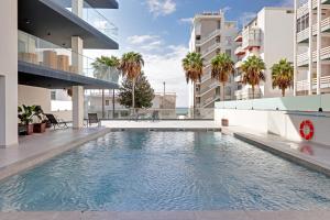 una piscina en la azotea de un edificio con palmeras en Sky Beach Apartment, en Quarteira