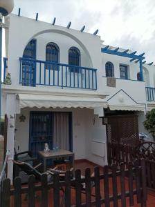 ein großes weißes Haus mit einem Tisch davor in der Unterkunft Apartamento situado en Maspalomas in Las Palmas de Gran Canaria