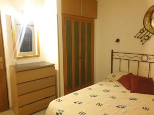 ein Schlafzimmer mit einem Bett und einer Kommode in der Unterkunft Apartamento situado en Maspalomas in Las Palmas de Gran Canaria