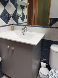 ein Badezimmer mit einem weißen Waschbecken und einer Toilette in der Unterkunft Apartamento situado en Maspalomas in Las Palmas de Gran Canaria + 4 Fotos