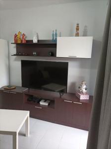 ein Entertainment-Center mit einem großen Fernseher im Wohnzimmer in der Unterkunft Apartamento situado en Maspalomas in Las Palmas de Gran Canaria