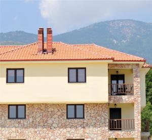 uma casa com uma parede de pedra em Kaimak Mountain Lodge em Panayítsa