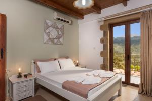 a bedroom with a large bed and a balcony at Villa Gianna by PosarelliVillas in Fílippos