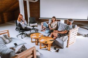 um grupo de pessoas sentadas numa sala de estar em Selina Peniche em Peniche